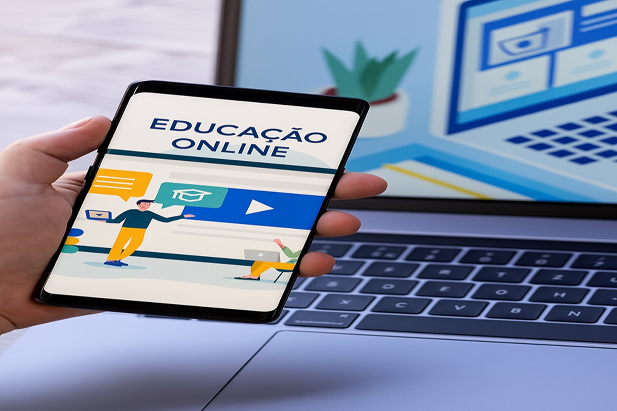 Smartphone exibindo conteúdo educacional digital, segurado por uma pessoa diante de um laptop