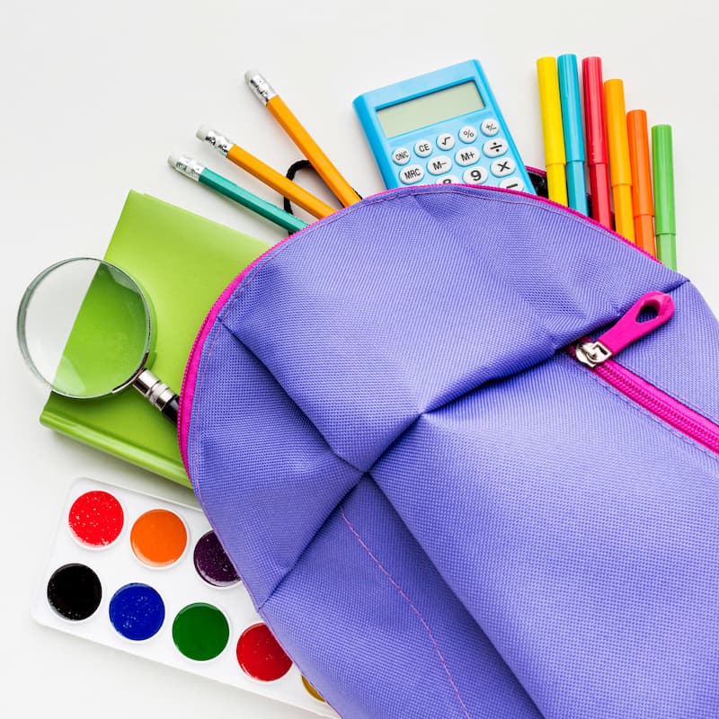 Postura plana de itens essenciais da escola com aquarela e mochila